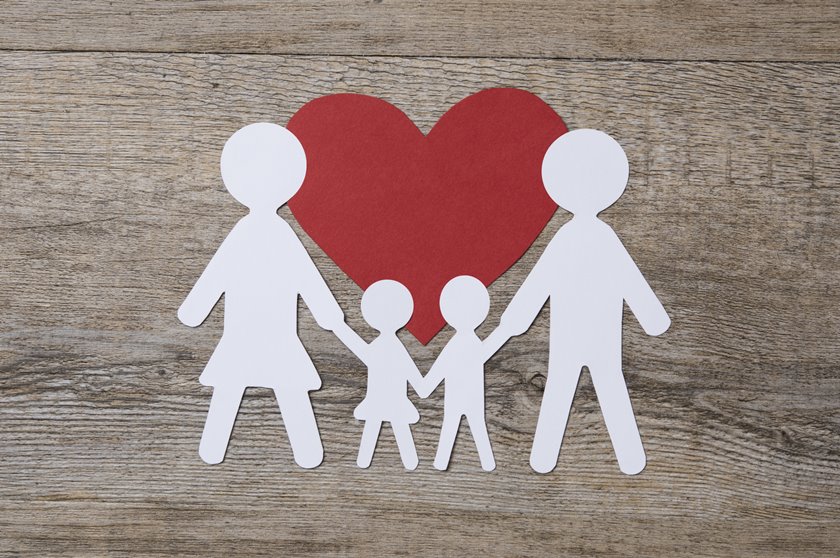 Top view of white paper chain family on red shape heart. Family in love. Family care and unity concept.