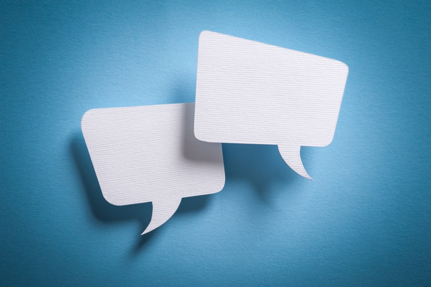 Photo of paper speech bubbles on blue background.